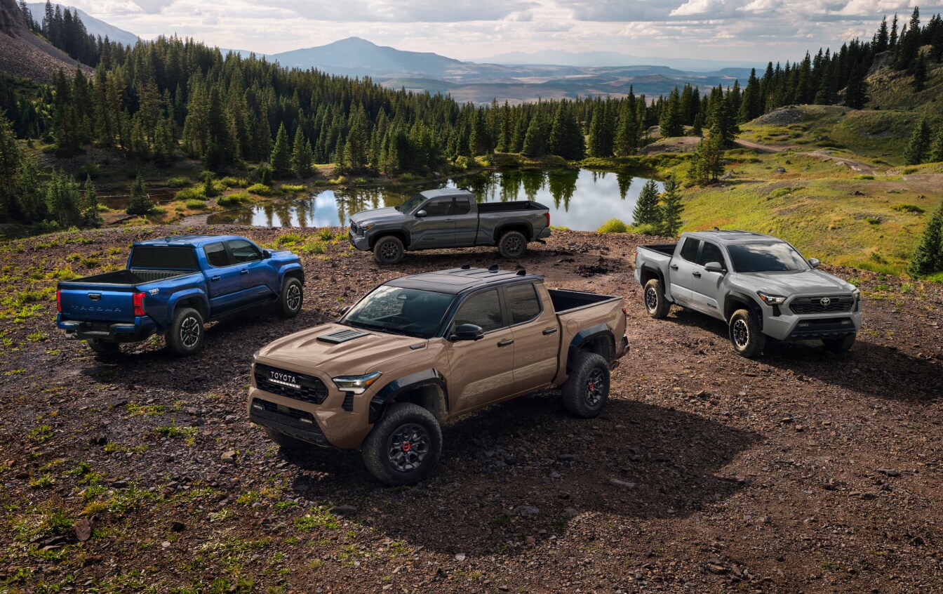 Four Toyota Trucks parked next to a small lake