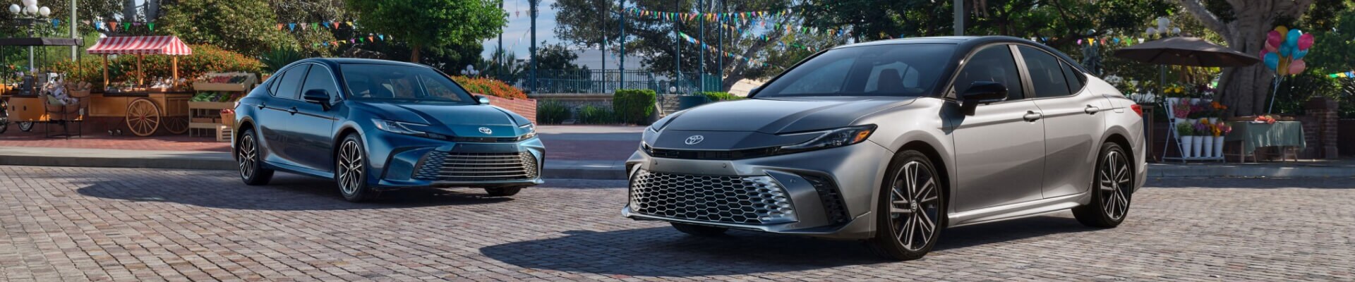 Toyota Camry XLE shown in Ocean Gem parked next to a Toyota Camry XSE shown in Heavy Metal with Midnight Black Metallic roof