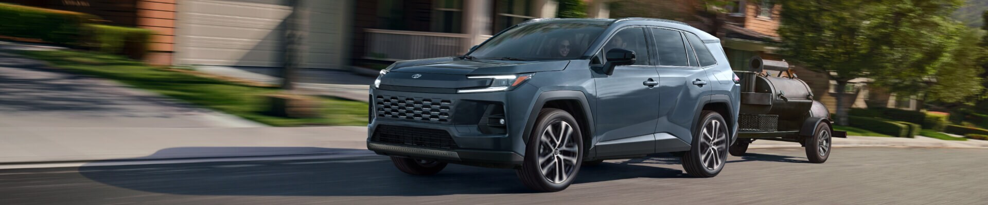 2025 Toyota RAV4 Hybrid in blue towing a smoker trailer