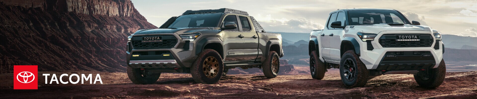 Two new Toyota Tacoma Trucks parked atop a cliff