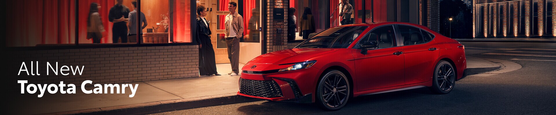 2026 Toyota Camry Hybrid Nightshade in Supersonic Red parked on a street corner