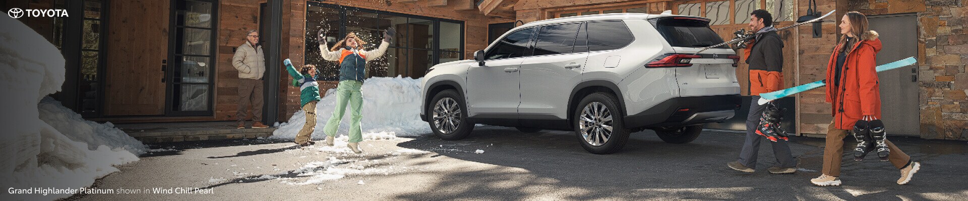 2024 Toyota Grand Highlander Platinum parked outside a snowy cabin in New England on a family ski trip