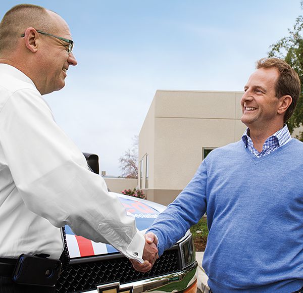 Car salesman shaking hands with customer