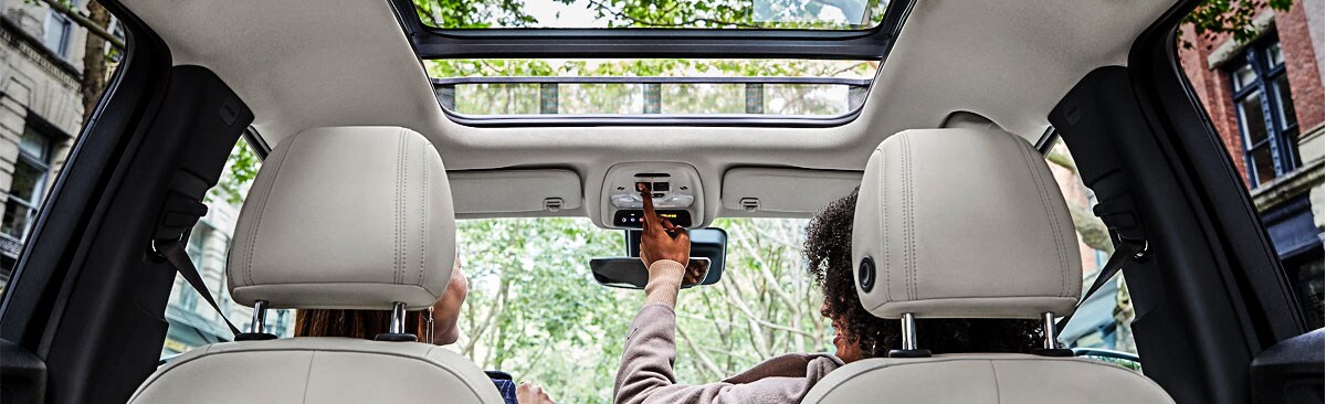 2020 Buick Encore woman opening the panoramic sunroof
