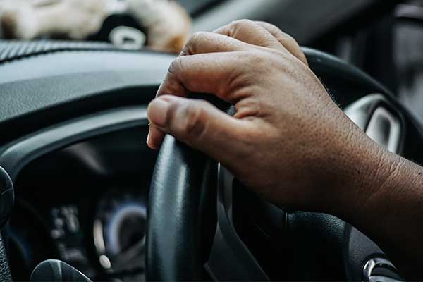 person driving with hands on the wheel