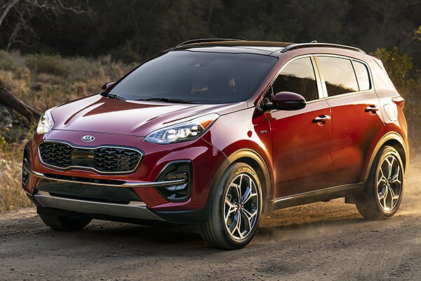 2020 Red Kia Sportage parked in a woody area