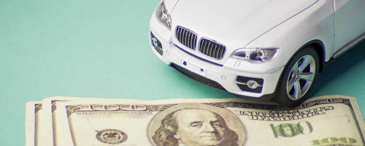 a-model-of-a-white-luxury-car-and-dollar-bills-on-2023-11-27-05-16-42-utc.jpg