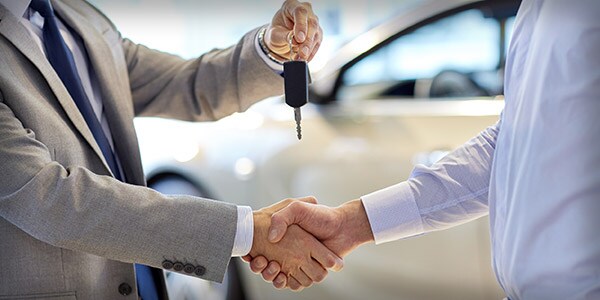 Car salesman shaking hands