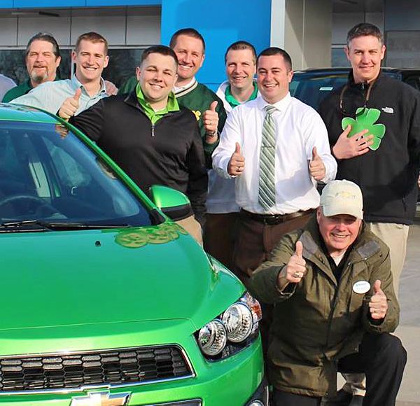 McGrath staff posing together by green car