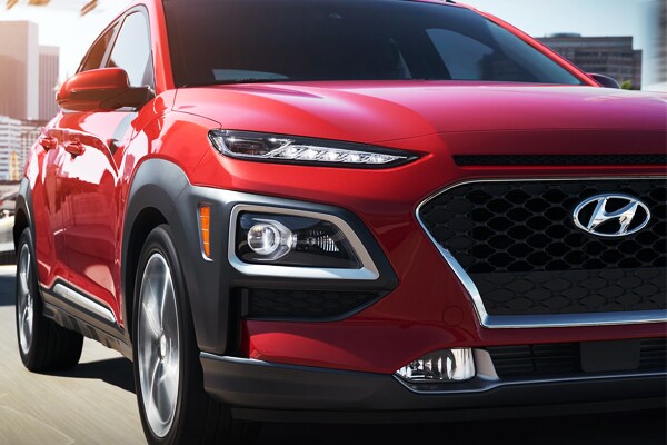 2019 Red Hyundai Kona Driving down the city block