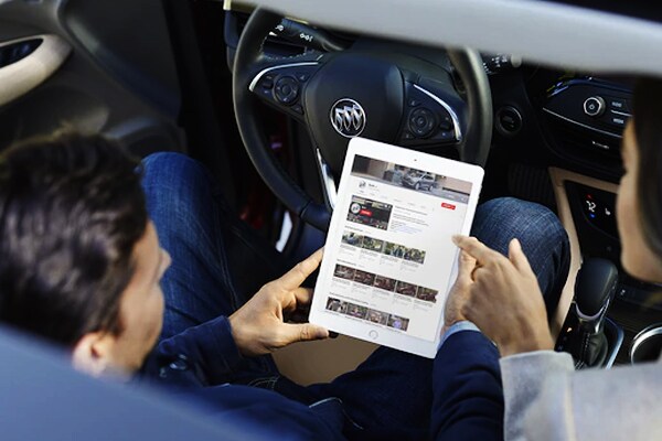 2019 Buick Envision Wifi Hotspot Connectivity Vehicle owners holding a tablet in their 2019 Buick Envision connecting to their wifi hotspot