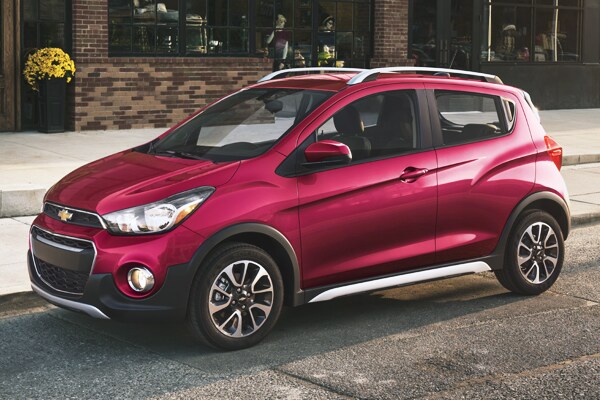 2019 Red Hot Chevy Spark parked next to a store