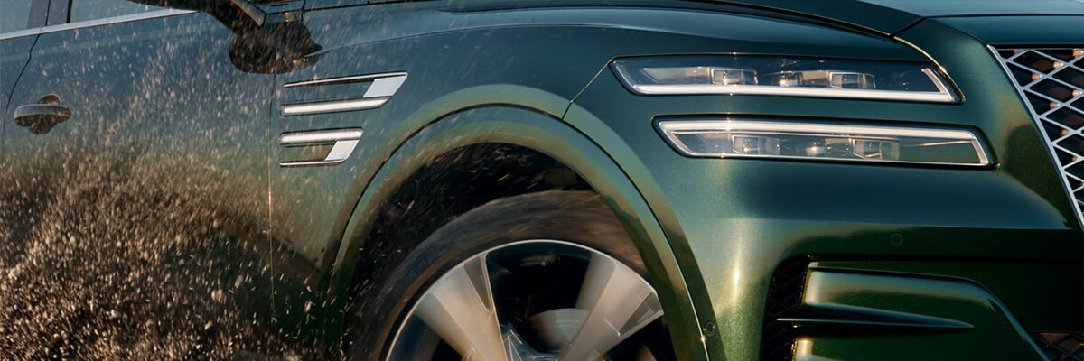 Grey 2021 GV80 Sport trim driving down a winding road