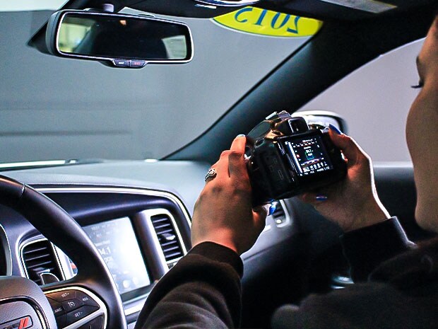 Young woman holding camera in car