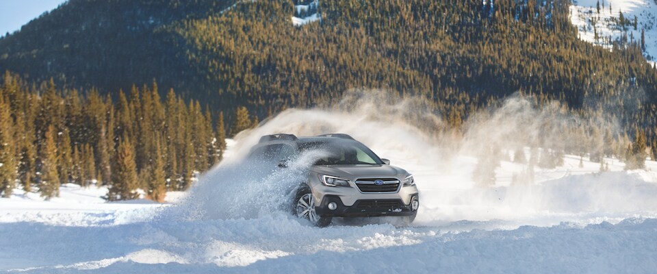 A 2019 Subaru Outback driving in the snow