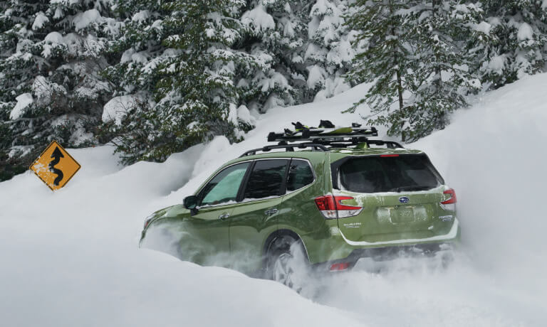 2020 Subaru Forester in green driving through deep snow