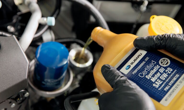 A mechanic pouring in approved car oil