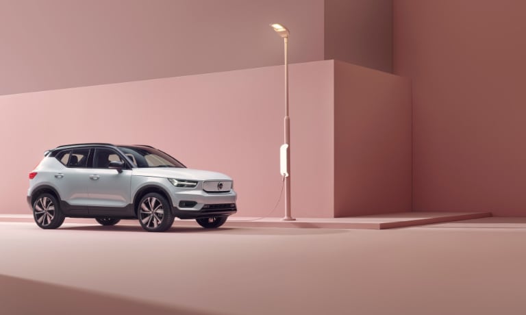 2020 Volvo XC40 Recharge in silver at a charging station with all pink walls and ground view from the front passanger side.jpg