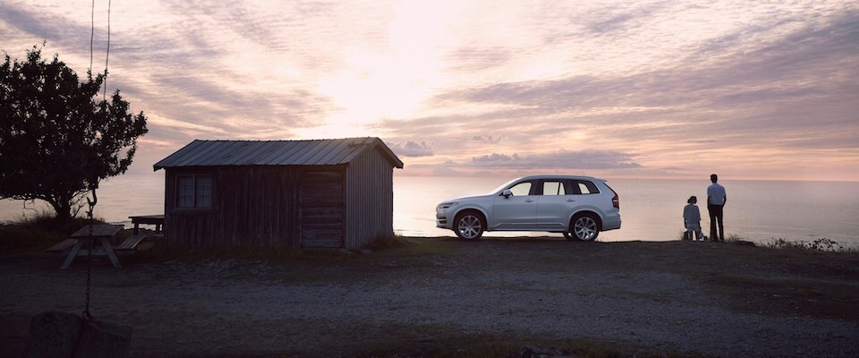 A Volvo XC90 parked by a lake at sunset