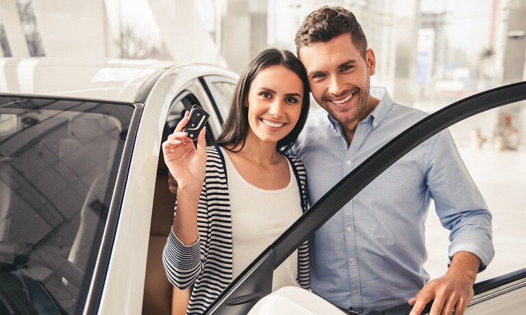 Couple smiling with car and keys