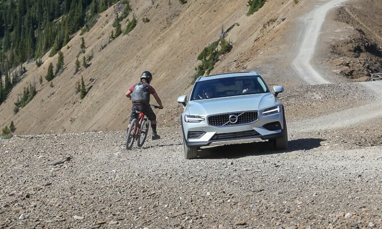 Volvo parked on a mountain next to a biker
