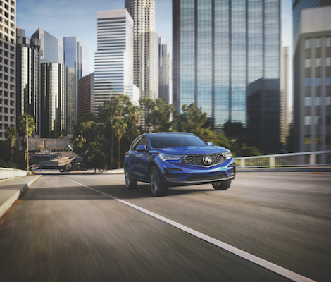 2019 Acura RDX A blue 2019 Acura RDX driving through an open city street