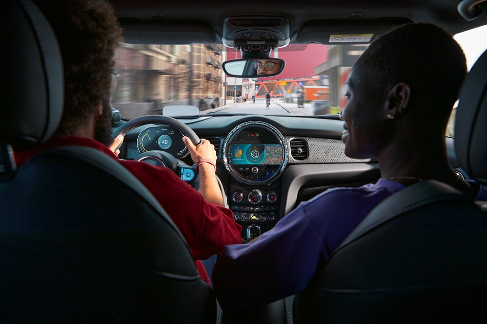 9.Alt Text A look over the right shoulder of a couple driving their 2022 MINI Co.png