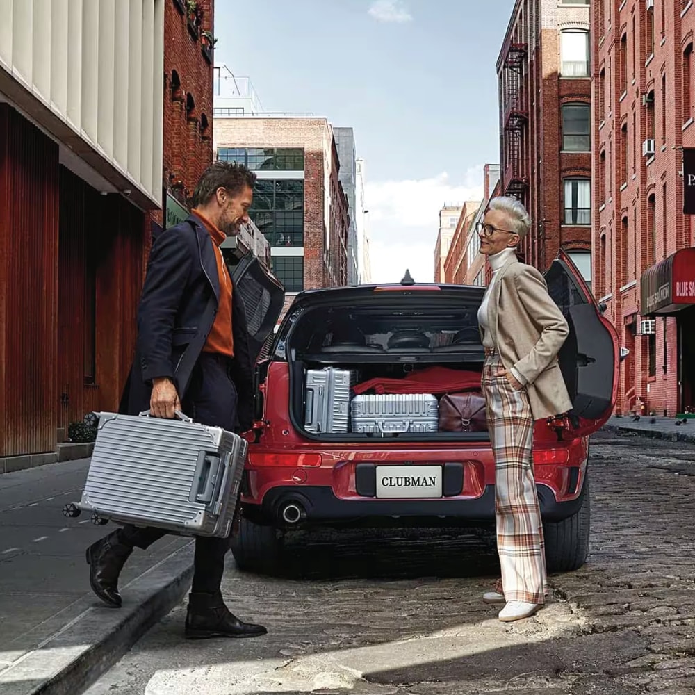 Image-9.png MAN AND WOMAN PACKING A MINI CLUBMAN WITH SUITCASES