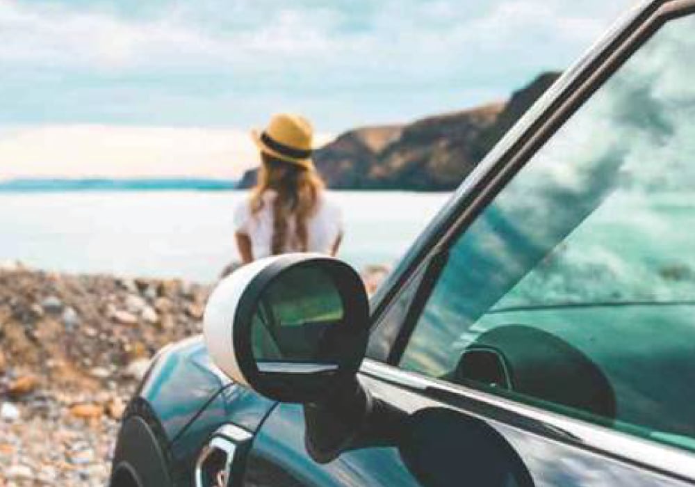 Image-3.png Woman sitting in front of a MINI next to the ocean