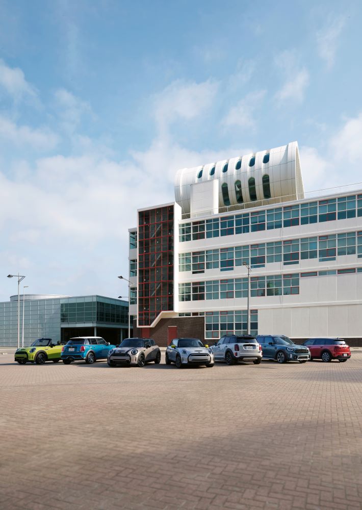 Up to $1,000 off select 2022 models. Family of MINI's parked in front of a building.