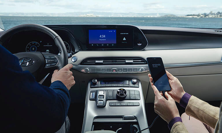 Couple in a 2021 Hyundai Palisade connecting a phone to the infotainment system