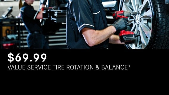 Mercedes-Benz Value Service Tire Rotation & Balance showing two technicians working on the tires of a Mercedes-Benz vehicle
