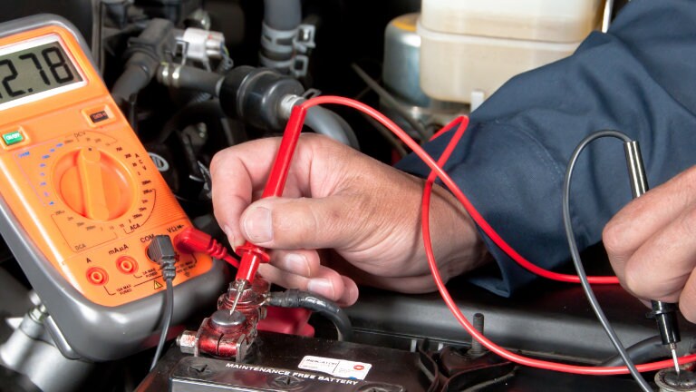 mechanic checking the battery on a car