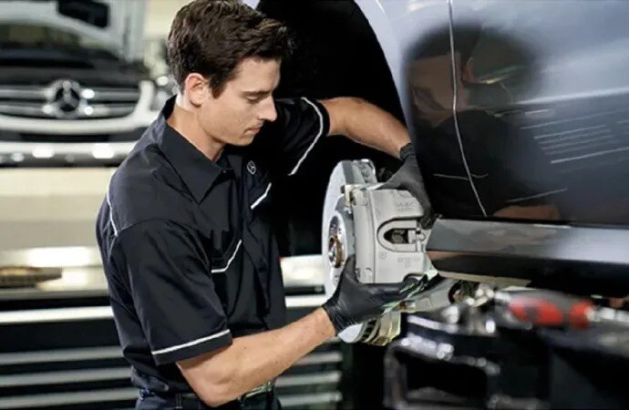 A technician performing service on a Mercedes-Benz vehicle