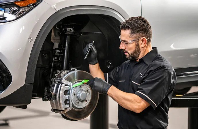 A technician performing service on a Mercedes-Benz vehicle