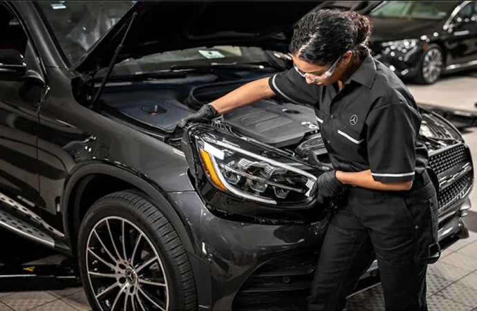 A technician performing service on a Mercedes-Benz vehicle