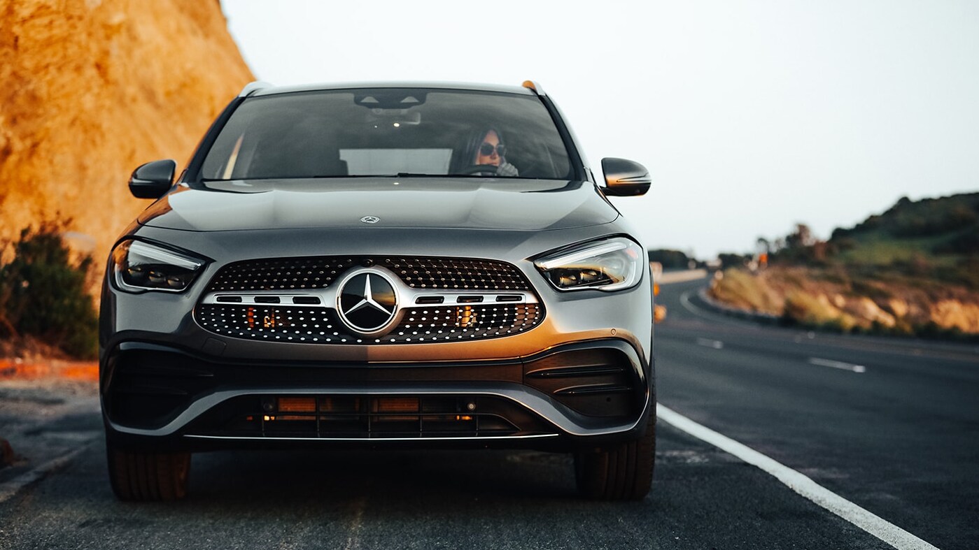 2022-mercedes-benz-gla-2.PNG A dark gray 2022 Mercedes-Benz GLA drives straight at the viewer, highlighting the grille of the car