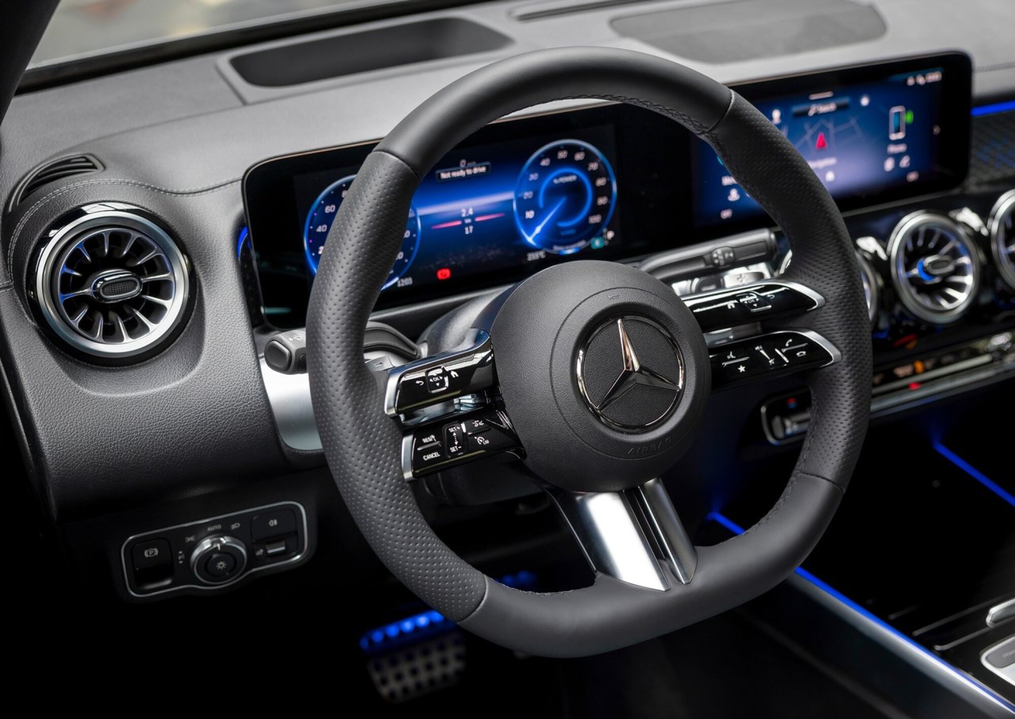 Mercedes-Benz-EQB-2024-1280-0d%20(1).jpg A close up of the steering wheel and dashboard inside the 2024 Mercedes-Benz EQB.