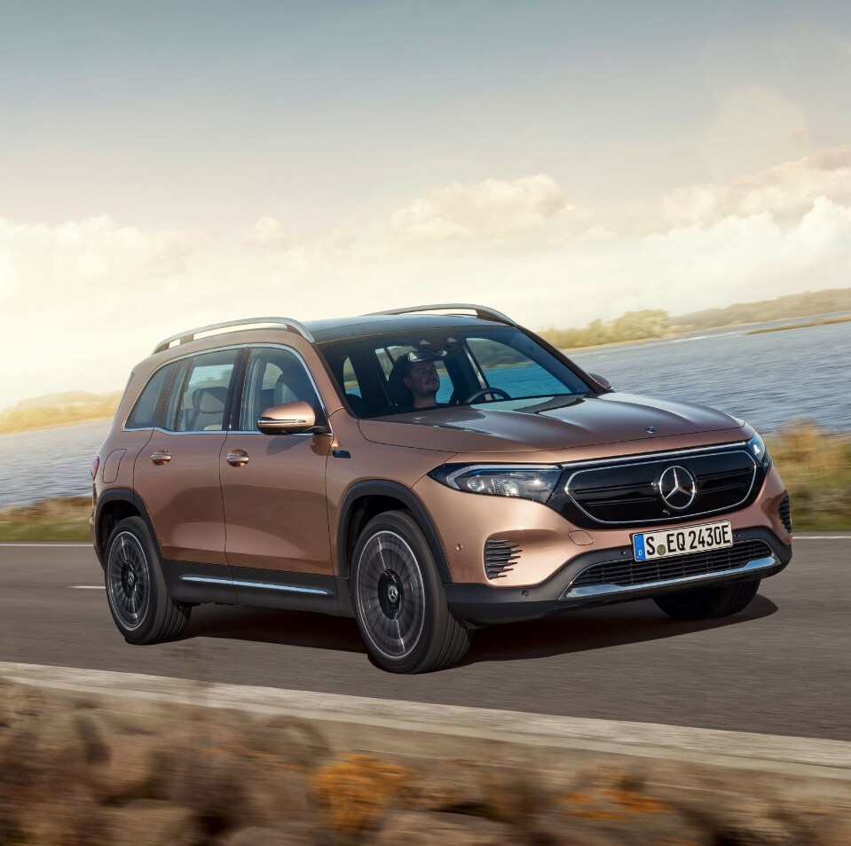 2022-Mercedes-Benz-EQB-3.PNG A 2022 Mercedes-Benz EQB in bronze drives past the viewer showing the front and profile