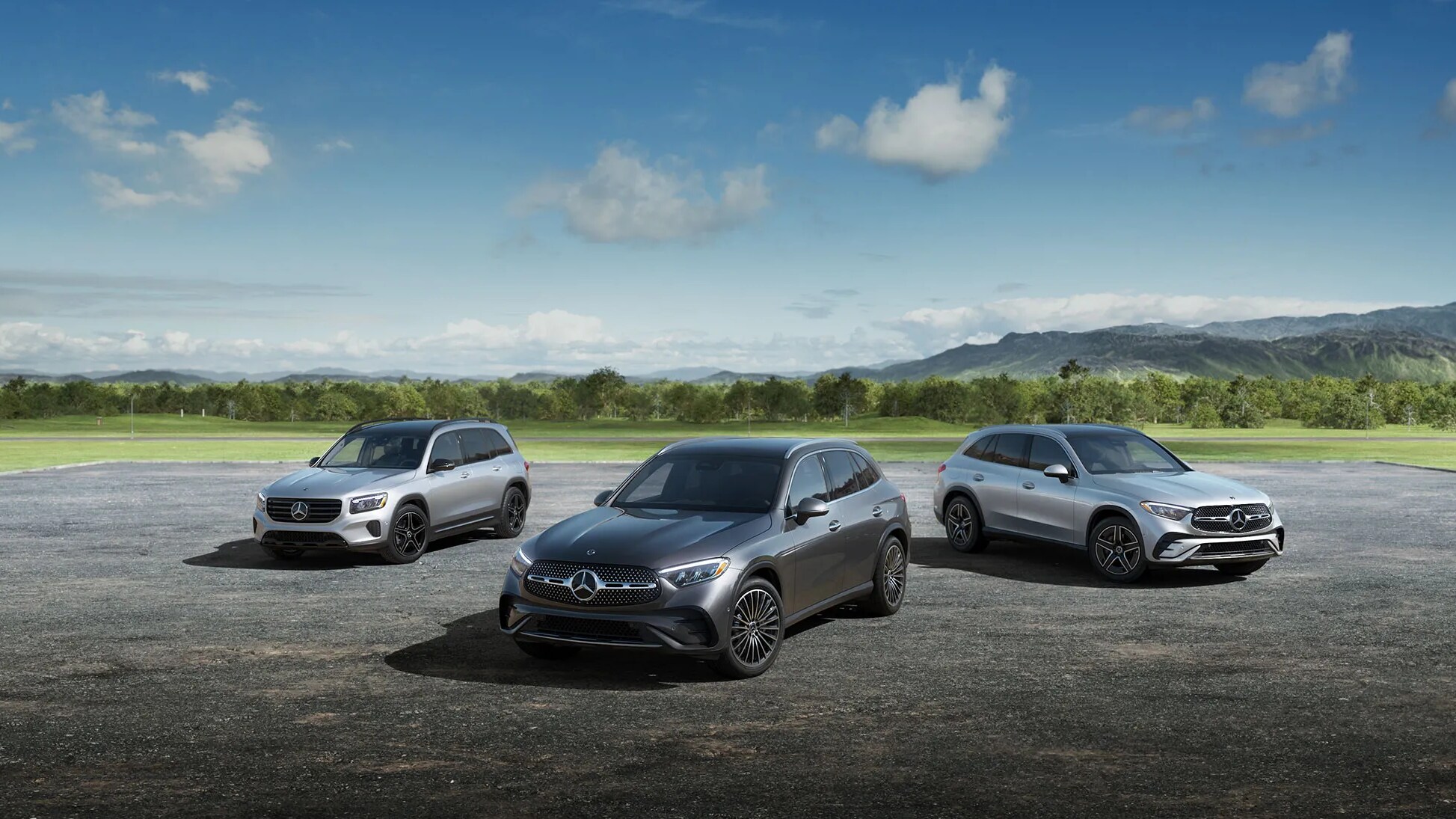 A lineup of three Mercedes-Benz SUVs parked outside in the sun