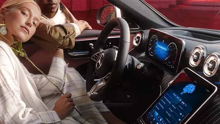 A driver and passenger using Mercedes-Benz technology