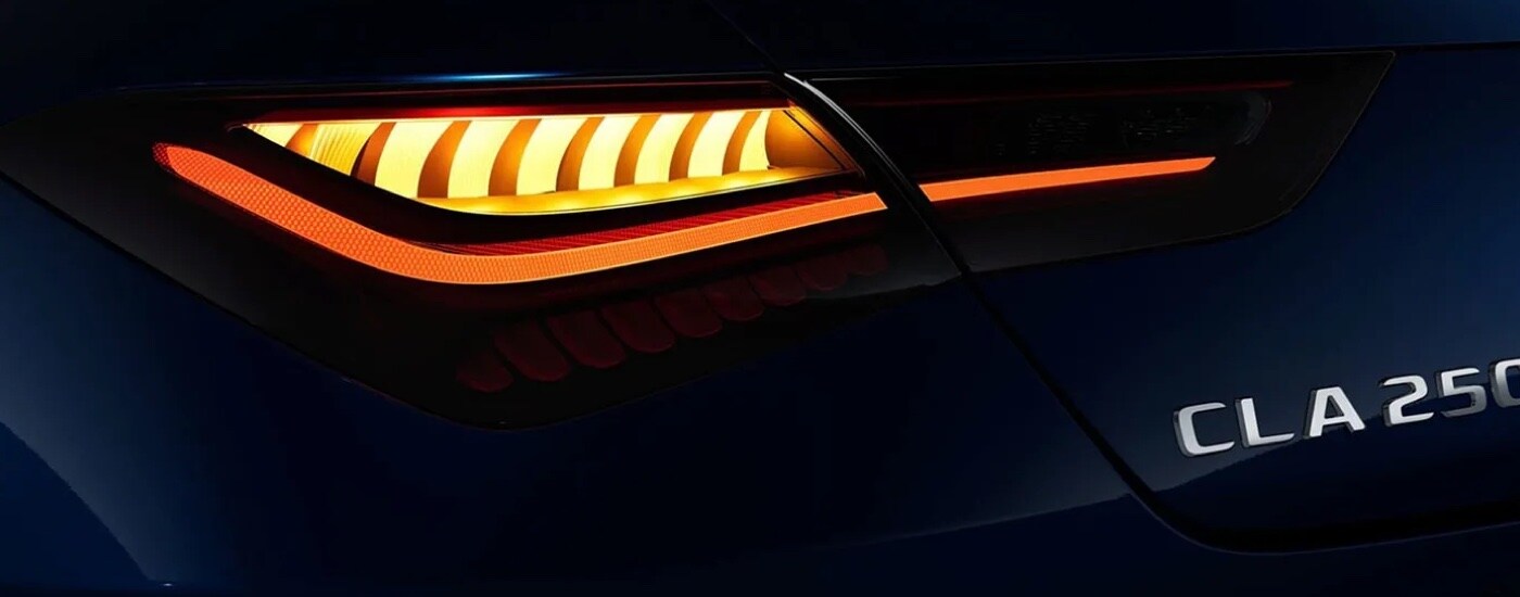 Close-up of the taillight and badge on the back of a blue 2024 Mercedes-Benz CLA 250 Coupe at a Mercedes-Benz dealer near Harrisburg.