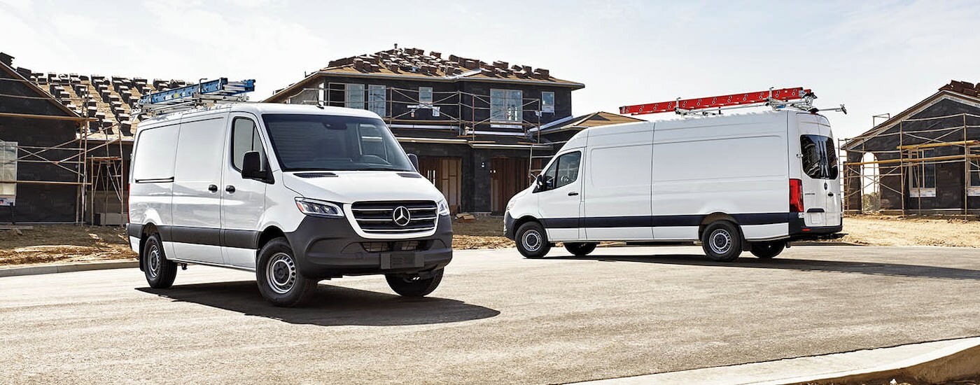 Two white 2024 Mercedes-Benz Sprinter 2500 vans parked at a construction site.