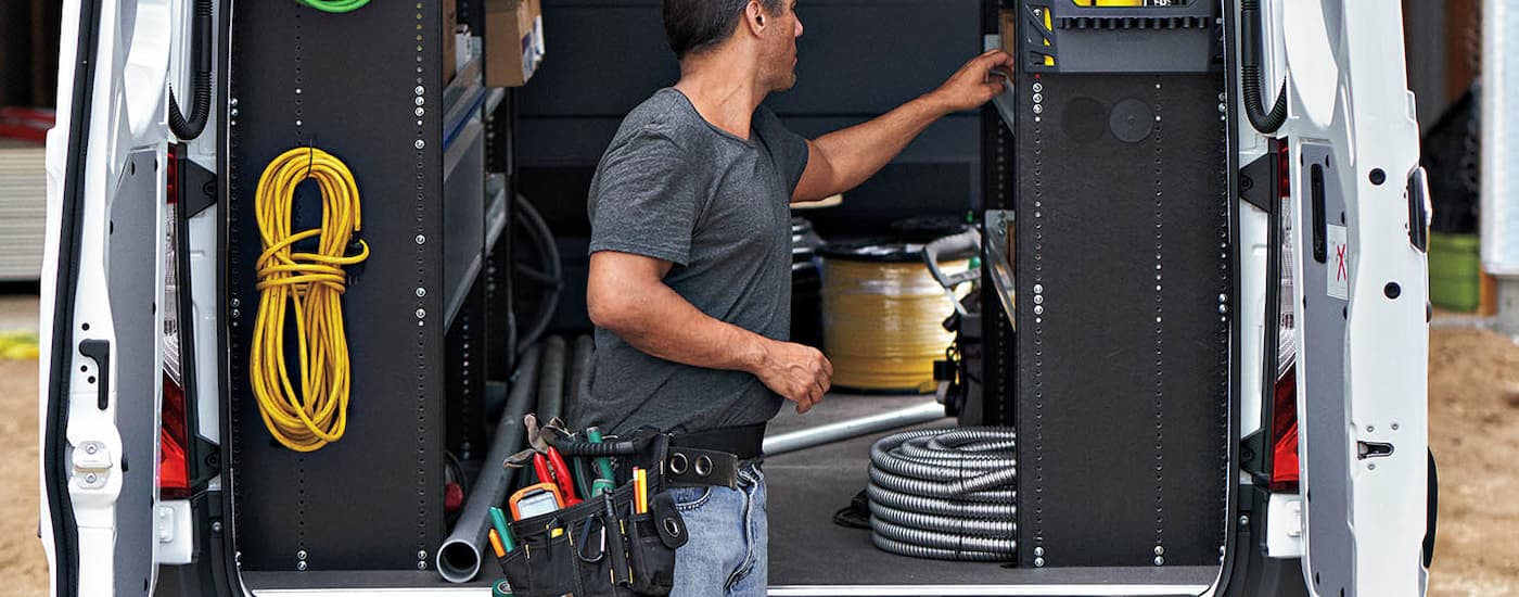 Mercedes-Benz%20Sprinter%202500%20for%20Sale%20in%20Medford%20-%202025%20Mercedes-Benz%20Sprinter%202500%20Cargo%20Van%20-%20Interior%20(1).jpg A man is storing supplies in the back of a 2025 Mercedes-Benz Sprinter 2500.