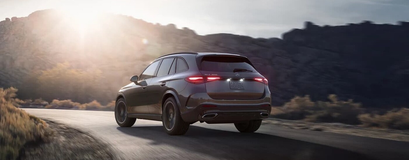 A grey 2023 Mercedes-Benz GLC is shown driving on a mountain road.