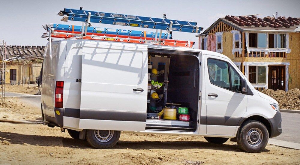 Side view of a white 2024 Mercedes-Benz Sprinter Cargo Van at a construction site.