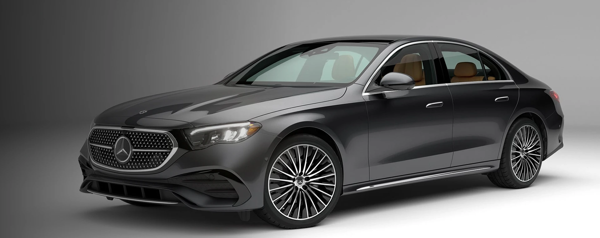 Dark grey 2027 Mercedes-Benz E 350 Sedan in a studio, seen from the front three-quarter