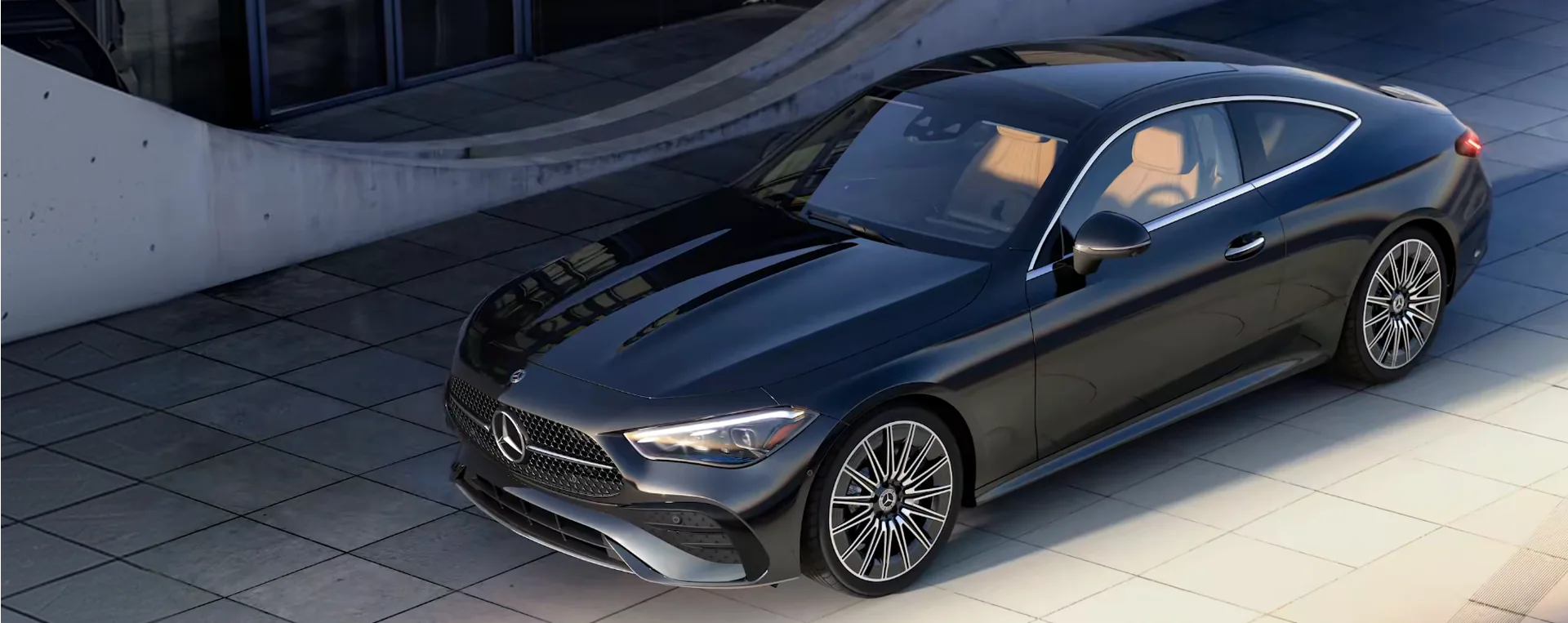 Black 2027 Mercedes-Benz CLE Coupe parked on a sunlit stone plaza