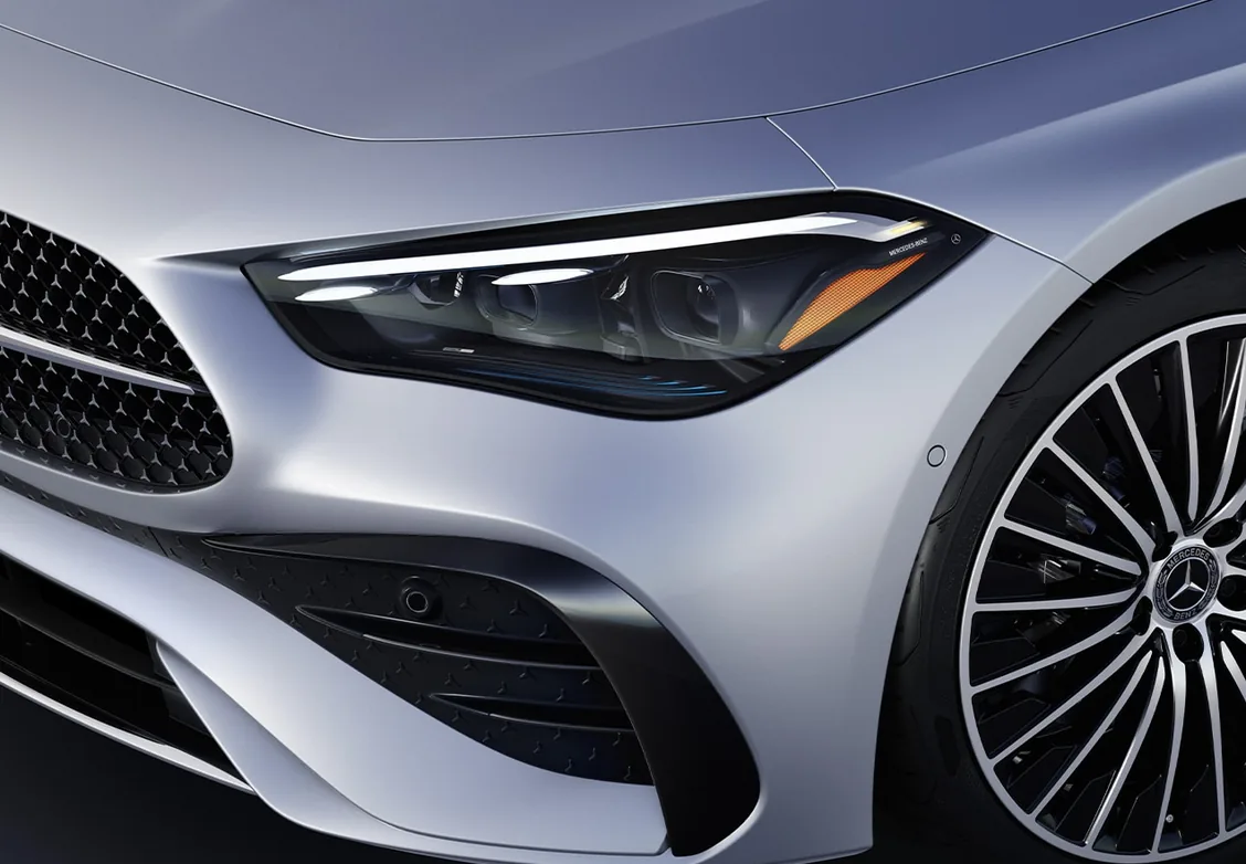 Close-up of the LED headlamp and multi-spoke wheel on a silver CLE Coupe
