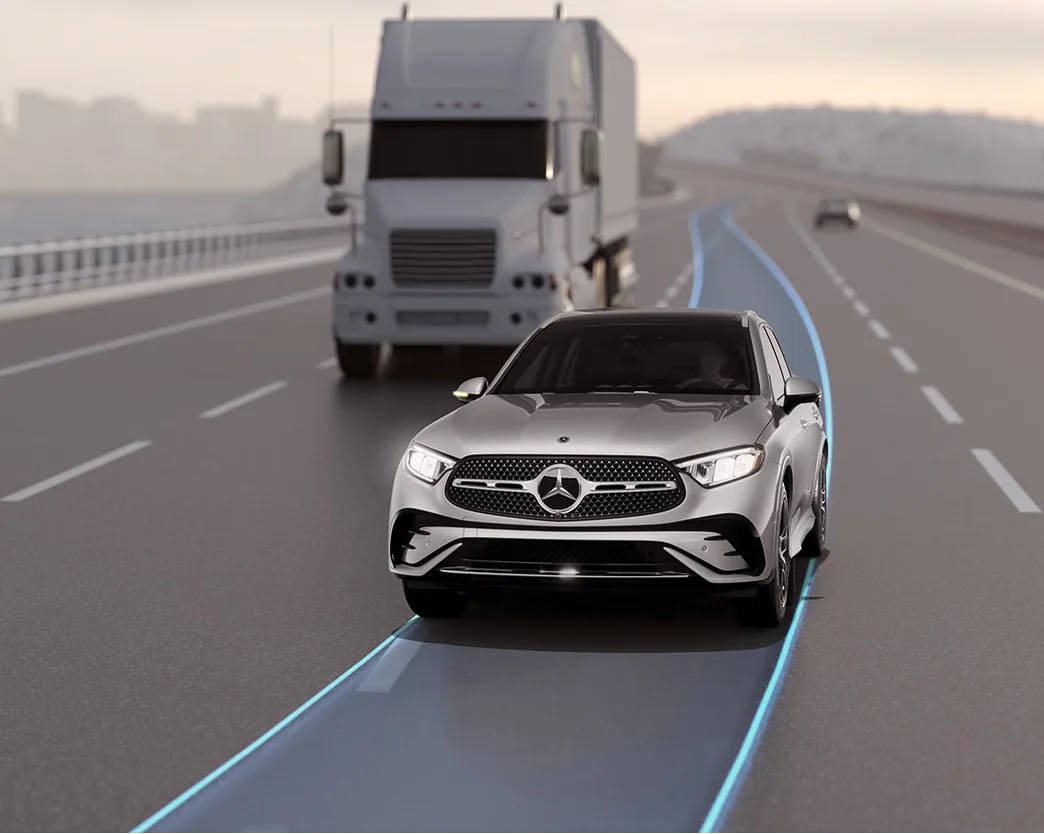 Silver GLC following a truck on a highway with adaptive cruise control lines shown